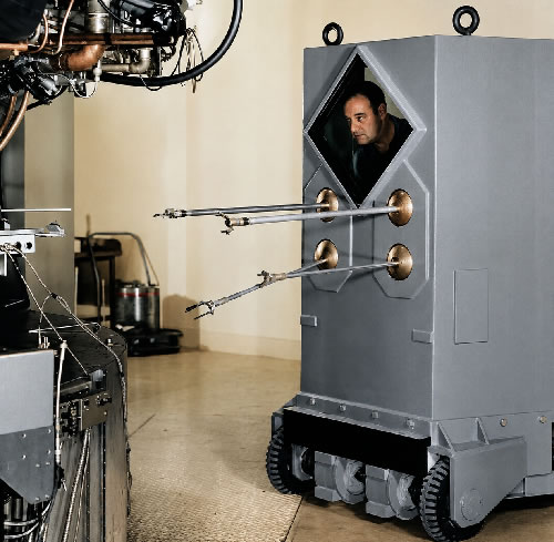 Cientista operando o manipulador remoto móvel com blindagem de chumbo em Argonne